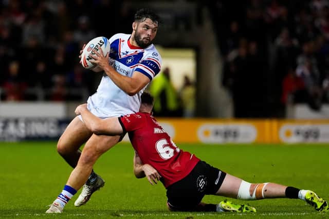 Wakefield Trinity's Matty Storton is tackled by Rowan Milnes, of Salford Red Devils, in a Super League game last August. Picture by Olly Hassell/SWpix.com.