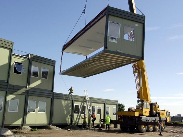 A unit is lowered into place as the temporary classrooms take shape at Pudsey Crawshaw School, following the fire. Picture on August 10, 2001.