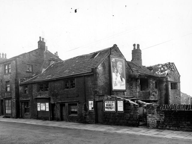 Old Hall, a derelict building on Bramley Town Street. A large poster advertises Player's Cigarettes; smaller ones publicise a local rugby match and a race meeting among others. Pictured in August 1956.