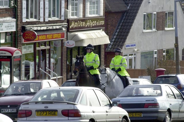 Mounted police pass Ireland Wood Post Office while on patrol in February 2001.