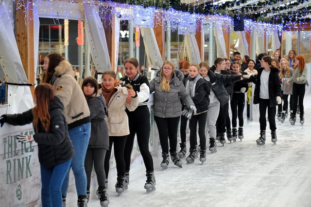 A group of skaters make their way onto the ice.