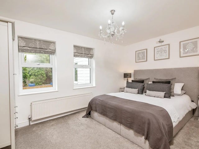 The master bedroom is connected to a white bathroom suite en-suite; two further bedrooms are created from the original integral garage.