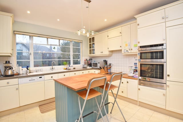 The cream coloured kitchen has a central island with breakfast bar.