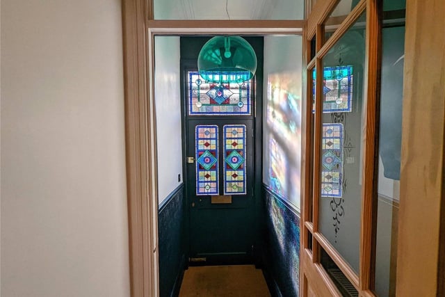 Steps to the front of the house provide access to an elevated ground floor, with an attractive front door with stained glass created by a local artist. There is a vestibule with tiled flooring and an inner door to a through hallway with stairs to the first floor.