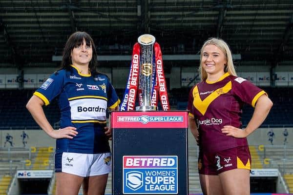 Rhinos captain Hanna Butcher, left, and Huddersfield's Bella Sykes pose with the Women's Super League trophy at Headingley. Picture by Allan McKenzie/SWpix.com.