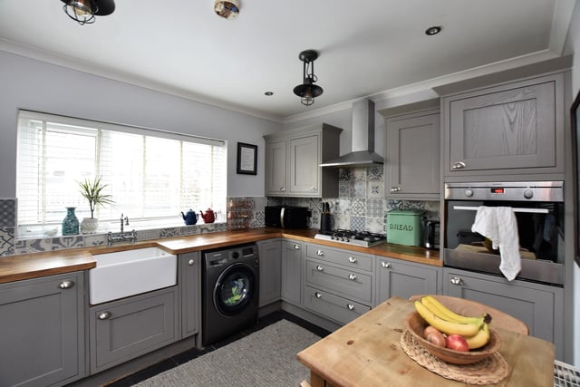 To the rear is the dining kitchen with a range of base and wall units, solid wood work surfaces, a Belfast sink, ceramic tiling, integrated dishwasher and ceiling inset spotlighting.