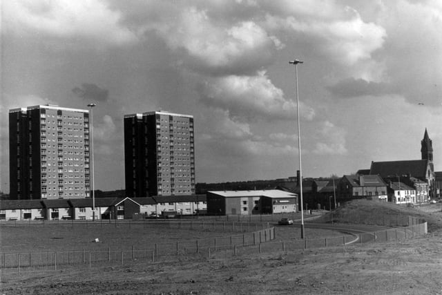 Dewsbury Road showing two blocks of high-rise flats, Crescent Grange (left) and Crescent Towers, built in 1969 at a height of 47 metres. Houses on Dewsbury Road and Moor Crescent Chase are on the left, then in the centre is the New Channing W.M. Club. St. Peter's C of E Church is visible in the background on the right. In the foreground is a slip road linking Dewsbury Road to the M1 Motorway (now designated the M621 at this point).