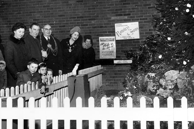 The Lord Mayor and Lady Mayoress of Leeds, Alderman Joshua S. Walsh and his wife, at the launch of the Leeds Council of Social Service Christmas Appeal in December 1966. The display features a Christmas tree and a garden with a nativity scene; the garden was presumably constructed by Rowley & Sons, Garden Constructors, of 3 Holt Lane, Adel, whose business is advertised on the wall behind.