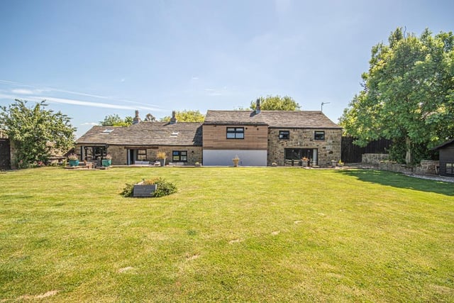 An extensive lawned garden has seating areas and a dedicated barbecue area.