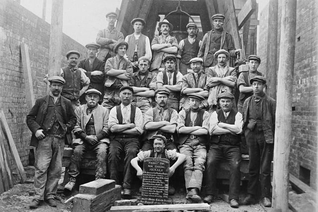 A group of workers employed in the sinking of a new shaft at Fanny Pit on Bullough Lane at Rothwell Haigh. Previously known as Midland Pit, the first shaft was sunk By J&J Charlesworth in 1867. The mine became known as Fanny Pit - after one of Charlesworth's daughters - after the new shaft was sunk in 1911. The old shaft was kept open for ventilation, with an additional ventilation shaft sunk in 1922. The boy seated at the front is holding a board giving the signals for raising and lowering the tub, or hoppett.
