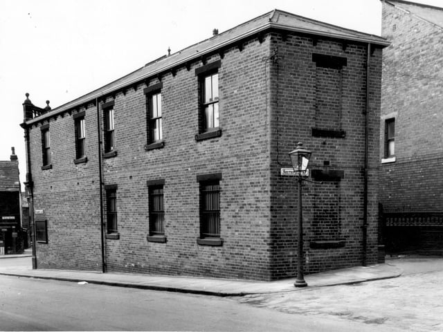 From the junction of Southfield Street and Strawberry Lane onto the side and back of number 172 Tong Road in June 1965. Bars can be seen on the lower windows. This is the Leeds Industrial Co-operative Society Ltd.