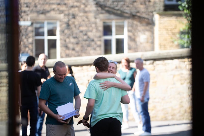 Parent hugging her child as he receives his GCSE results.