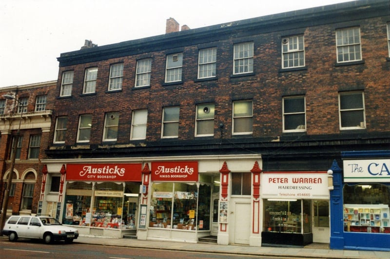 A parade of shops with run down offices above. On the left is Austicks H.M.S.O. Bookshop, then Peter Warren hairdressers. On the far right  is the Carmel Religious Bookshop. In 1992 this building was redeveloped and opened as shops, offices and a bar.