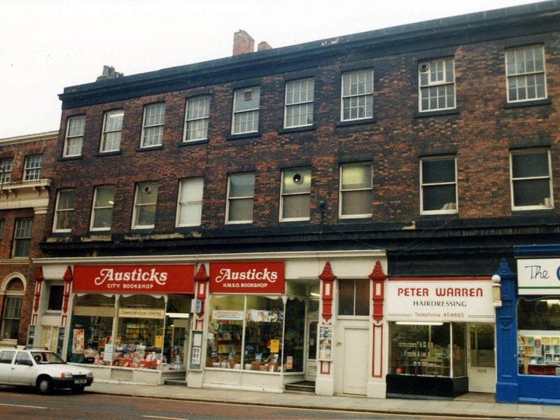 A parade of shops with run down offices above. On the left is Austicks H.M.S.O. Bookshop, then Peter Warren hairdressers. On the far right  is the Carmel Religious Bookshop. In 1992 this building was redeveloped and opened as shops, offices and a bar.