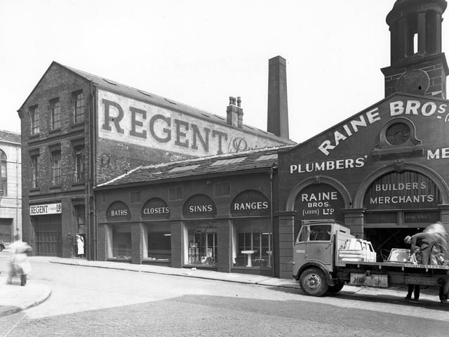 Crown Street at the junction with Assembly Street in the city centre, showing Regent (Printers) Ltd. (Crown Works), and at number 27, Raine Brothers (Leeds) Ltd, ironmongers and plumber's merchants. In the foreground, two men load sinks onto a flat backed lorry. To the left, a worker stands in Regent's doorway.