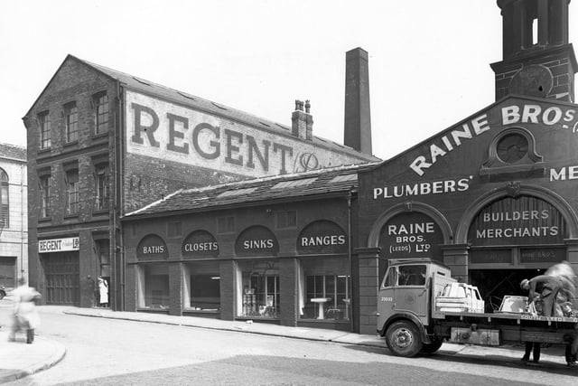 Crown Street at the junction with Assembly Street in the city centre, showing Regent (Printers) Ltd. (Crown Works), and at number 27, Raine Brothers (Leeds) Ltd, ironmongers and plumber's merchants. In the foreground, two men load sinks onto a flat backed lorry. To the left, a worker stands in Regent's doorway.