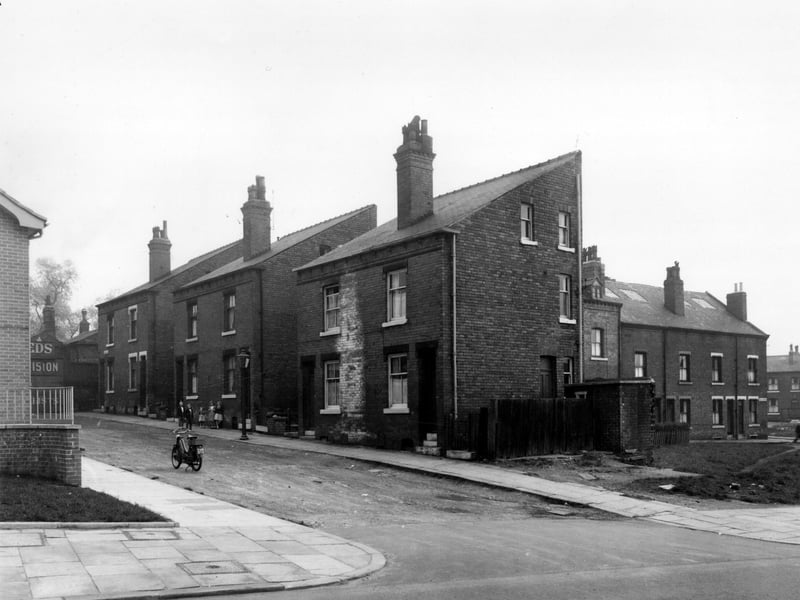 Raby Mount, seen from Sheepscar Street, in May 1958. Just seen on the left edge is the wall of a new Police Section House. At the end of Raby Mount, premises belonging to G.W. Binns, motor garages are visible. On the right is Yeomanry Street.