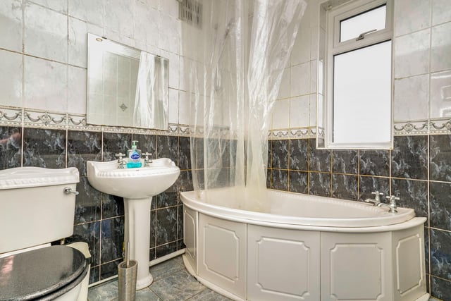 The modern family bathroom comes with a bath and shower unit and gorgeous tiling.