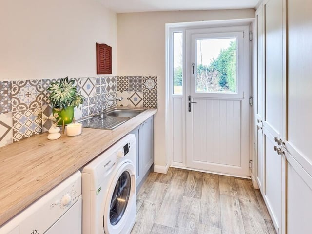 Space for laundry appliances, a large ‘American style’ fridge and further pantry storage can be found in the utility room.