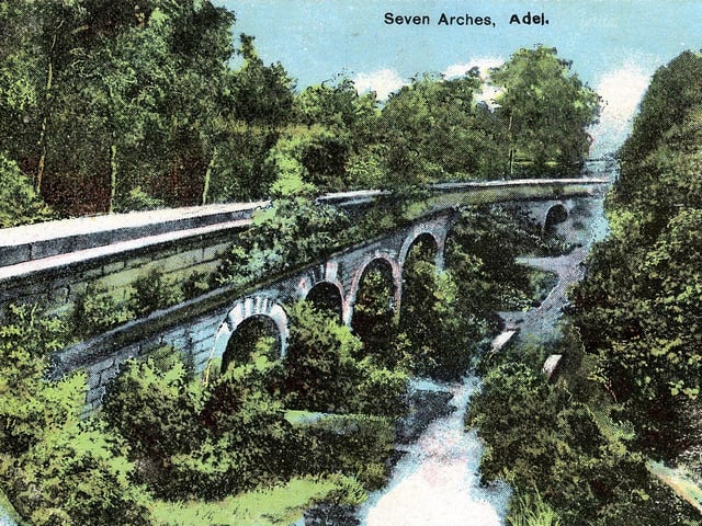 The seven arches aqueduct carried water from the Eccup Reservoir (built 1837) to the city centre. Underground pipes and tunnels carried the water for most of the six mile route, however at Adel it must cross the Adel Beck, for this reason the aqueduct was built. A postcard from April 1906.