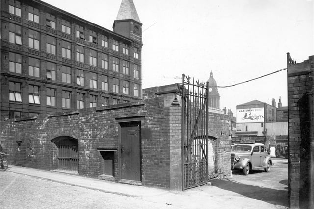 The Electricity Department Sub-Station in foreground on Somers Street. American car to right of picture. Advert for National Benzola Mixture and Town Hall clock tower in background. Pictured in April 1949.