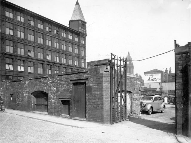 The Electricity Department Sub-Station in foreground on Somers Street. American car to right of picture. Advert for National Benzola Mixture and Town Hall clock tower in background. Pictured in April 1949.