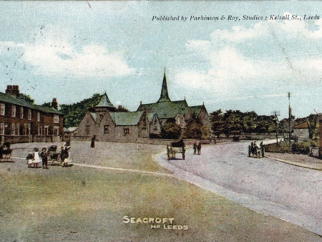 A colour tinted postcard of Seacroft with a postmark of August 24, 1904. The view looks along Town Street, as York Road was known at the time, towards the National School and St. James's Church in the centre. Backhouse Yard is to the left and Marshall's grocery store on the right. Several people, including children, can be seen as well as horses and carts.