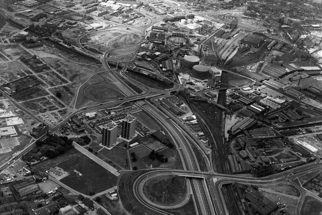 An aerial view of Hunslet showing the M1 running up from the bottom, passing the tower blocks of Crescent Grange and Crescent Towers on its left and Hunslet Gas Works further up on its right. Dewsbury Road leads off to the bottom left with Burton Row on the corner. Sweet Street leads up to the top left. The railway line runs to the right of the M1 with the A61 crossing it at the bottom right. At the centre right is Leathley Road, while further up are Hunslet Road, Hunslet Lane and Great Wilson Street, leading towards the city centre.