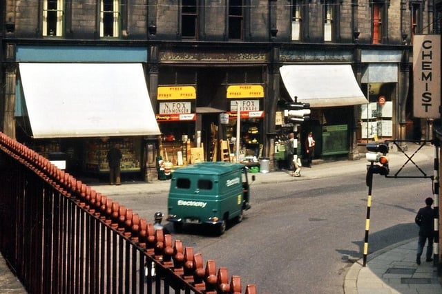 Cheapside, Morley Bottoms, as viewed from the balcony of the 1840s buildings at the bottom of Scatcherd Hill which were demolished for road widening in 1966. The traditional type of shop in Cheapside - grocer, ironmonger, boot and shoe repairer and insurance agent - have been replaced by more specialised services as trade began to fall off due to difficulties in parking and competition from the supermarkets. Pictured in Juky 1965.