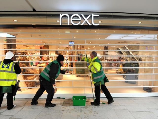 Cleaning the shutters at Next ahead on opening day.