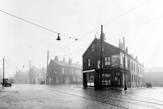 On the left, second block of buildings is a branch of Yorkshire Penny Bank pictured in November 1938. It opened on June 1, 1931. Moving right is the junction with Raincliffe Street, then Leonard Dean, newsagents shop and William Dawson, draper. Next is the junction with Everleigh Street. No.190, premises of E.Davis, family butcher, next no.188 John Redmans' fruit shop. An advertisement for Cherry Blossom shoe polish is over the shop door. Street in view is Chantrell Grove.