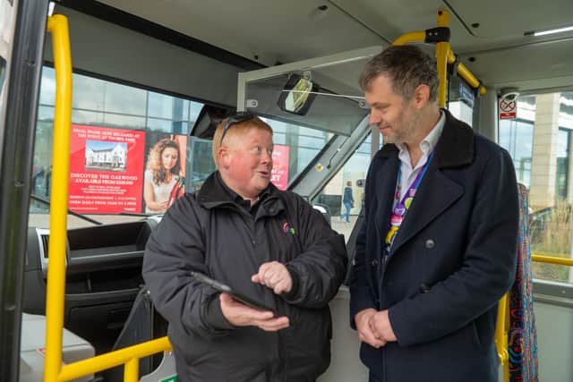 FlexiBus driver Sarah shows Coun Carlill how to book a trip on the app. (Photograph by Richard Walker/ImageNorth)