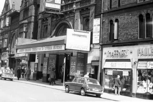 This view looks along New Briggate onto the Grand Theatre in August 1966.  The theatre was designed by George Corson and opened in 1878. The theatre seats 3,150 and is decorated in red and gold. It is now the home of National Opera North and the Northern Ballet Theatre. To the right of this view is Shaffners jewellers at number 44 New Briggate, then Paul's Modern Menswear.