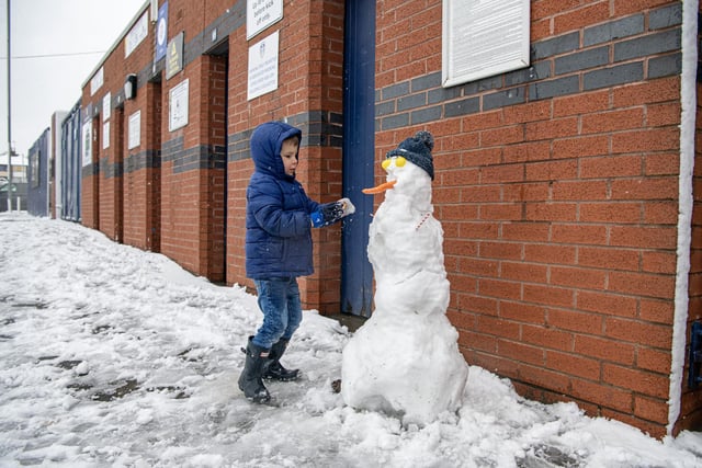 Reggie Middleton, 4, makes a snowman by the turnstiles at Elland Road. Staff from the club were clearing the are in preparation for Leeds United's  Premier League match with Brighton and Hove Albion.