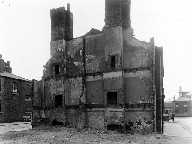 Back-to-back properties on Spring Street West to the left and North Hall Street to the right. Fireplaces can be seen on each floor and part of the party wall between the two properties is still standing. Pictured in July 1950.