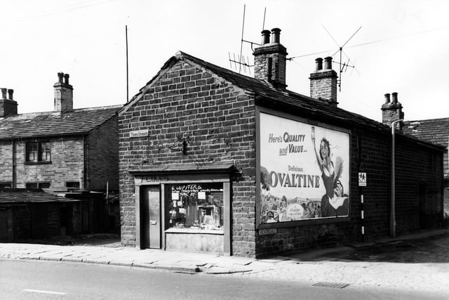 On the far left can be seen the houses on Elmwood Place with a row of shared outside toilets in front. The shop visible at number 62a Town Street is Coles selling transisters with a six month guarantee. On the right is Vickersdale where a road sign warns drivers of children on the road belonging to Stanningley Church of England Primary School. Also here an advertising hoarding promotes Ovaltine. Pictured in September 1963.