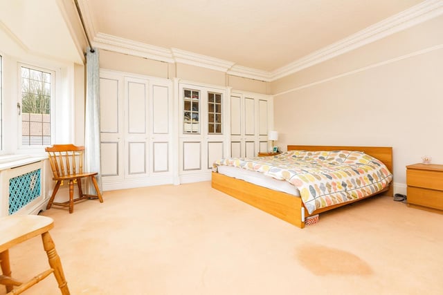 This spacious bedroom has fitted wardrobes and decorative coving.