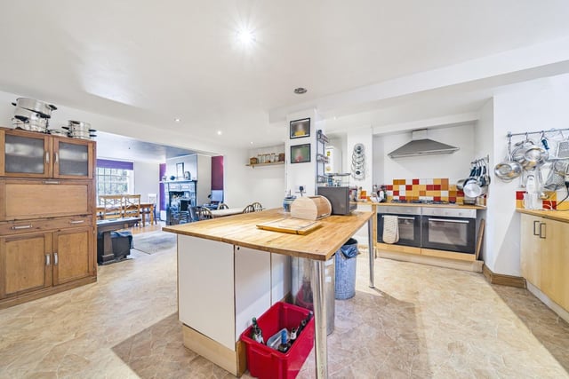 The kitchen area features a range of base units and a centre island with breakfast bar.