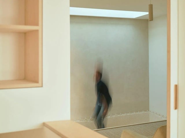 The third sleeping area lies at the rear and typifies the inherent playfulness of the home; spanning the large floor void, a giant roped net allows the dappled skylight to filter down to the floors below and is the perfect spot to relax and watch projected films.