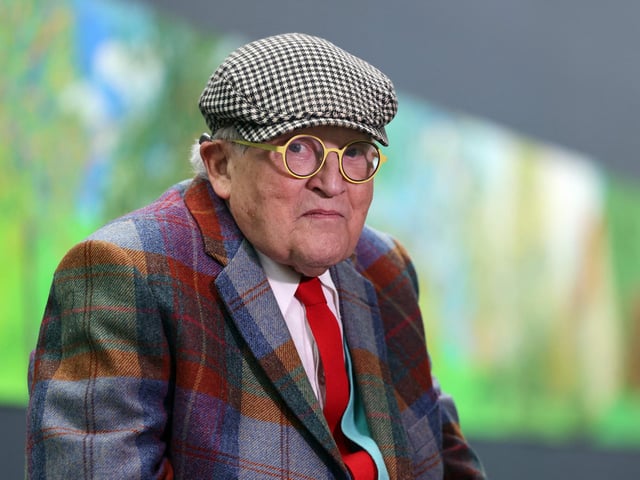 British painter David Hockney poses at the Orangerie museum in Paris, on October 7, 2021, in front of his painting "A year in Normandy", a 91-meter-long artwork painted during the lockdown in 2020.