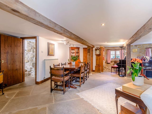 A sitting and dining area with flagstone flooring fill the main floor space at ground floor level.