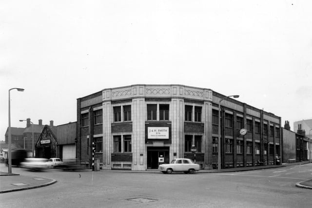 Whitehall Road runs from the left edge to the bottom right corner of this view from March 1965 with Spence Lane running from the bottom left corner to the right edge. In the centre to the right edge. In the centre is Corner House. Built around the early 20th century this building was first used as the offices of Ideal Stores Ltd. In this view it is the premises of J. and H. Smith Ltd, tools and hardware merchants.