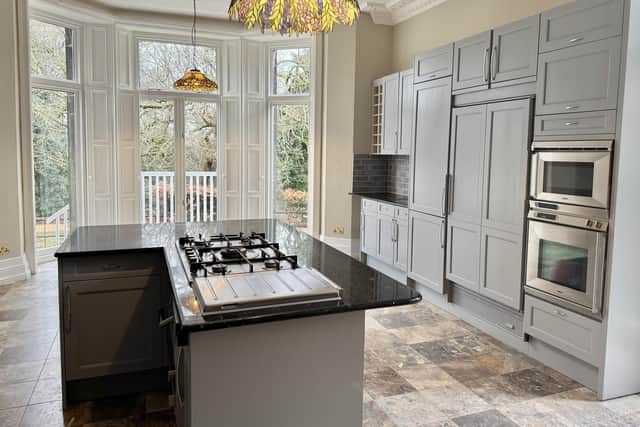 Apartment A at The Hollies features a generous kitchen with a central island, breakfast bar and integrated appliances. There is a large bay window with full-height windows and access out to the gardens.