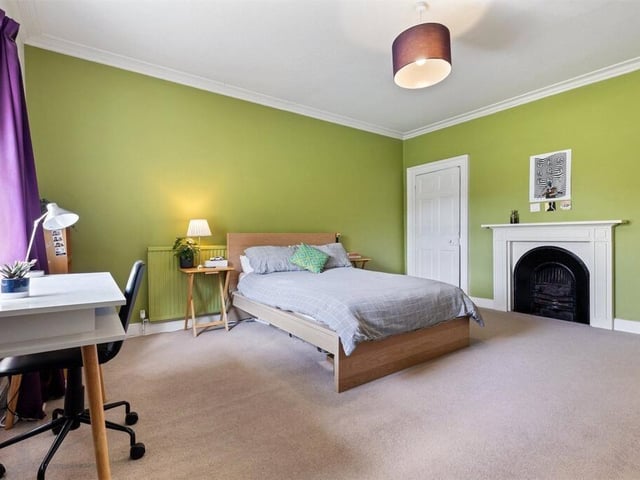 A generously proportioned double bedroom offers a calm, restful atmosphere with ample space for storage and seating.