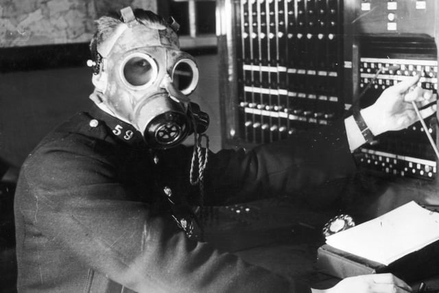 A Chesterfield Borough Police telephone operator tests a gasmask with built in earpiece and microphone in 1939. The telephone service was considered one of the most important links in the coordination of ARP (Air Raid Precautions) operations during the Second World War and had to operational during air raids.