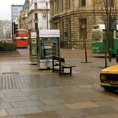 The Headrow seen from the junction with Cookridge Street. Park Row is on the left. Two advertising display boxes can be seen in the centre. A van is parked in the foreground and two buses are visible. Pictured in November 1980.