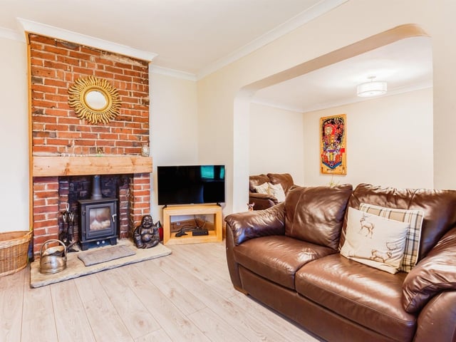 A feature brick fireplace holds a warming stove within the lounge area.