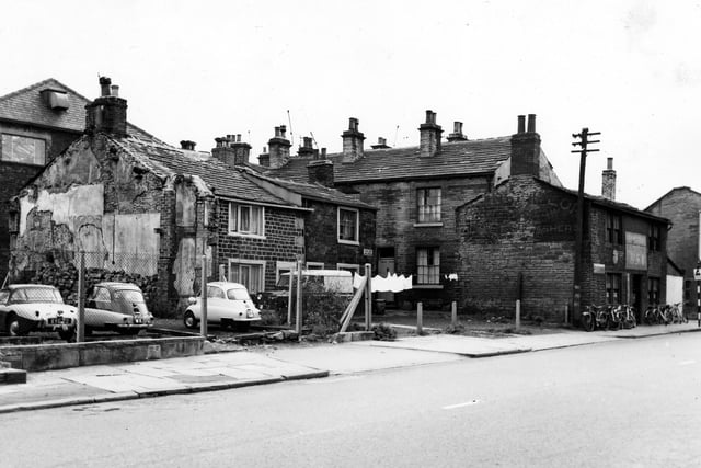 Fowler's Buildings on Town Street in August 1963. On the far right is the T.H. Wortley cycle shop where cycles are lined up on the pavement outside. On the left of the image cars are parked in a wire fenced in plot of land. Two of the cars are Heinkel bubble cars. These were a popular form of transport in 1960s as the tiny car was taxed as a motorcycle and cheap to run.