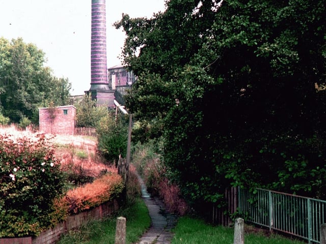 The chimney of Highbury Works, formerly Meanwood Tannery, seen from a footpath leading off Highbury Mount by the north end of Highbury Lane. It was taken shortly before the chimney, made of brick with red painted reinforcing steel straps, was demolished in 1998.