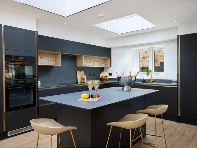 Handleless black and gold cabinetry provides plenty of storage, stylishly finished within the kitchen. Integrated appliances include an oven, hob, extractor hood, sink, fridge, freezer and dishwasher.